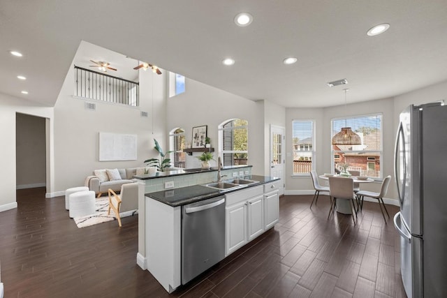 kitchen featuring a sink, white cabinetry, appliances with stainless steel finishes, dark wood-style floors, and dark countertops