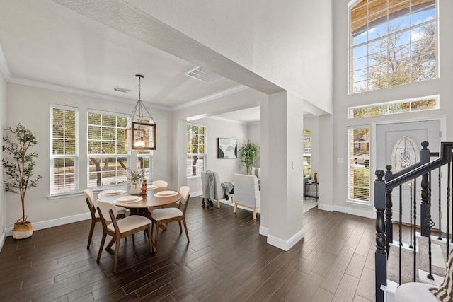 dining area with dark wood-type flooring, visible vents, ornamental molding, and stairs