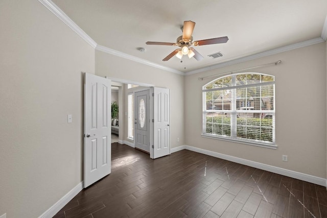 empty room with dark wood finished floors, visible vents, and baseboards