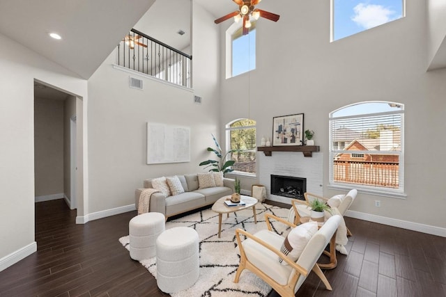 living room with a fireplace, wood finished floors, visible vents, and baseboards