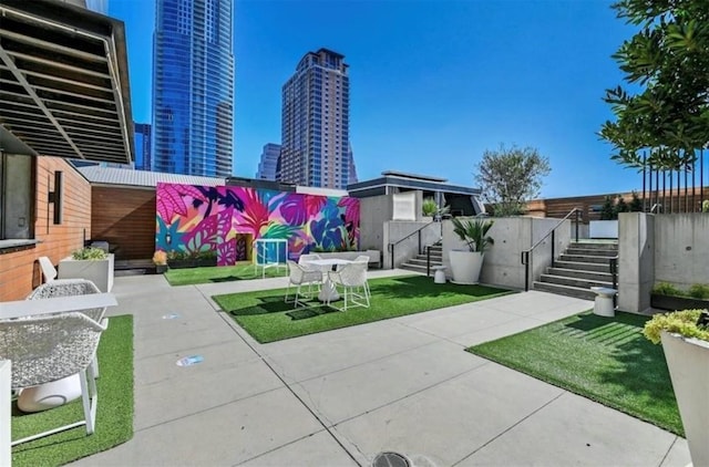 view of patio / terrace with a view of city and fence