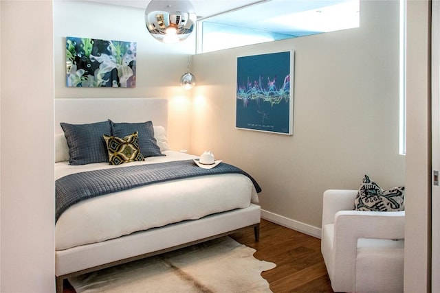 bedroom featuring baseboards and wood finished floors