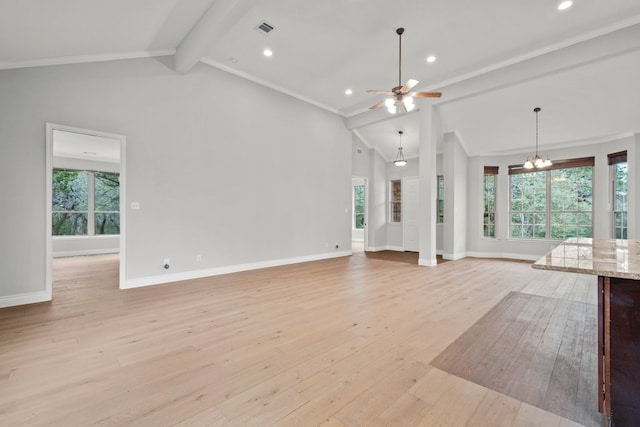 unfurnished living room with a wealth of natural light, visible vents, beamed ceiling, and light wood-style flooring