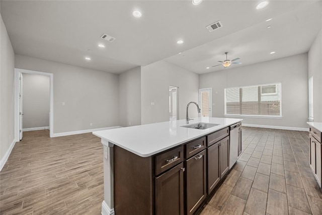 kitchen with stainless steel dishwasher, visible vents, open floor plan, and a sink