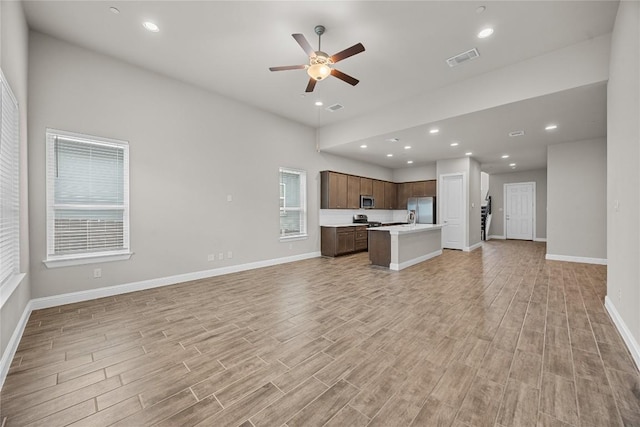 interior space featuring recessed lighting, light wood-type flooring, visible vents, and baseboards