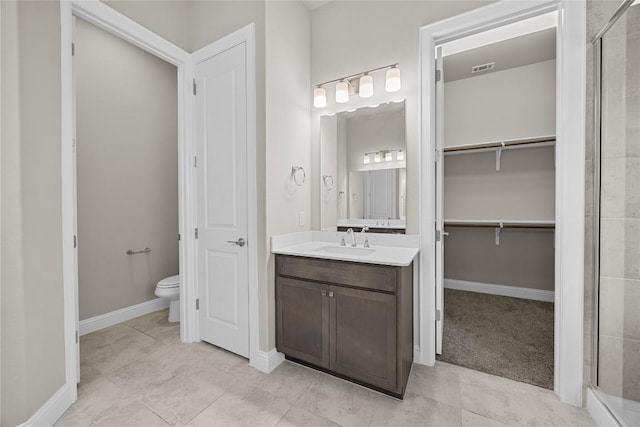 bathroom with a spacious closet, a stall shower, vanity, and toilet