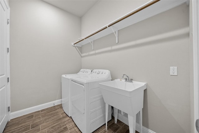 laundry room featuring laundry area, baseboards, wood tiled floor, washer and dryer, and a sink