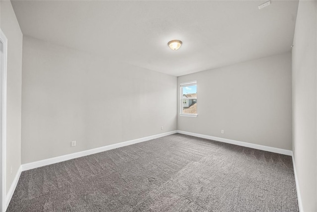 carpeted spare room with baseboards