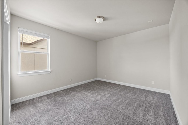 empty room featuring carpet floors and baseboards