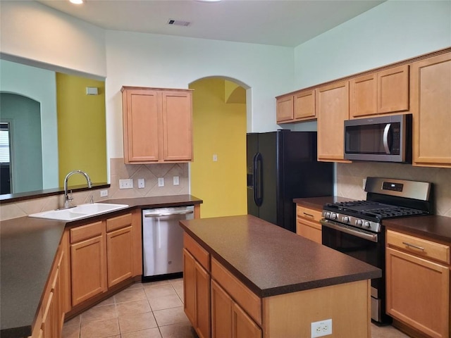 kitchen featuring visible vents, a sink, dark countertops, appliances with stainless steel finishes, and decorative backsplash