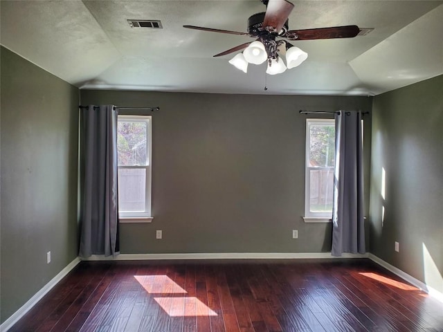 empty room featuring visible vents, plenty of natural light, and hardwood / wood-style flooring