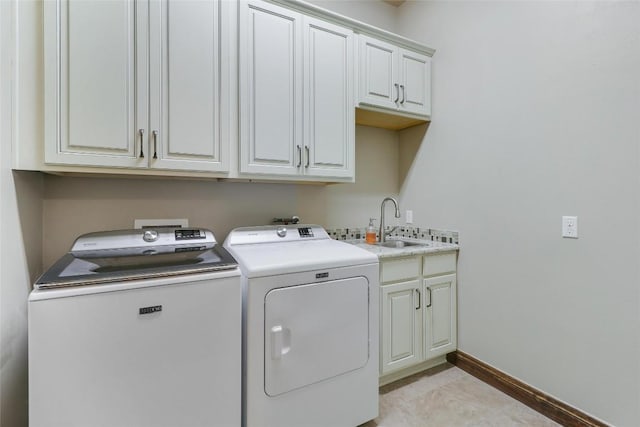 washroom with cabinet space, separate washer and dryer, and baseboards