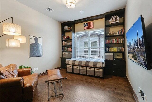 sitting room with wood finished floors, baseboards, and built in features