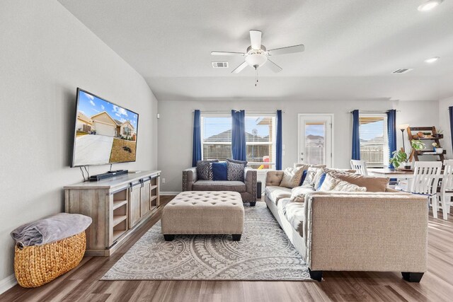 living area featuring a healthy amount of sunlight, visible vents, and wood finished floors