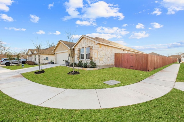 view of home's exterior featuring a garage, concrete driveway, stone siding, fence, and a yard