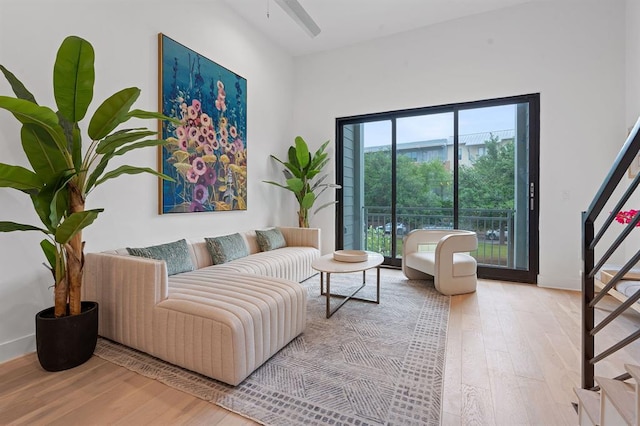 living area featuring light wood-style flooring and stairs