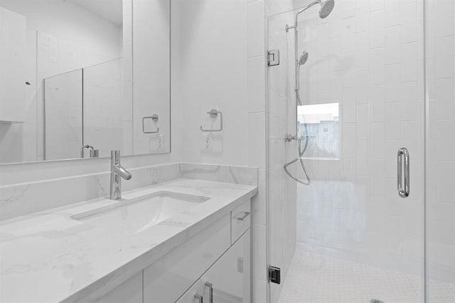 bathroom with a shower stall and vanity