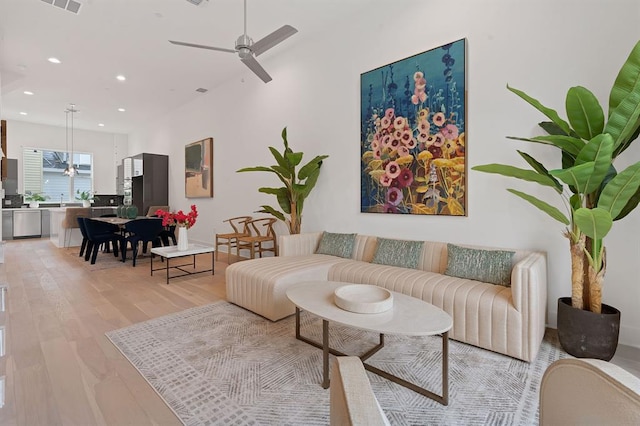 living area with a ceiling fan, recessed lighting, visible vents, and light wood finished floors