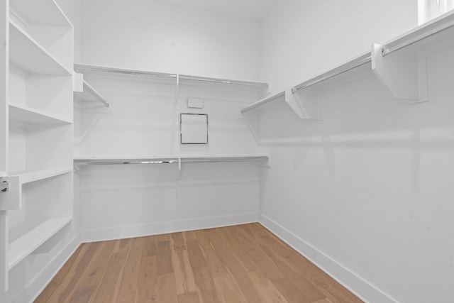 walk in closet with wood finished floors