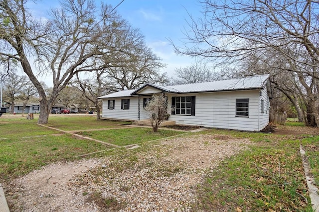 view of front of house with metal roof and a front yard