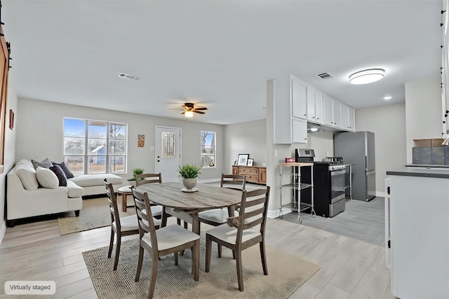 dining room with light wood-style floors, visible vents, ceiling fan, and baseboards