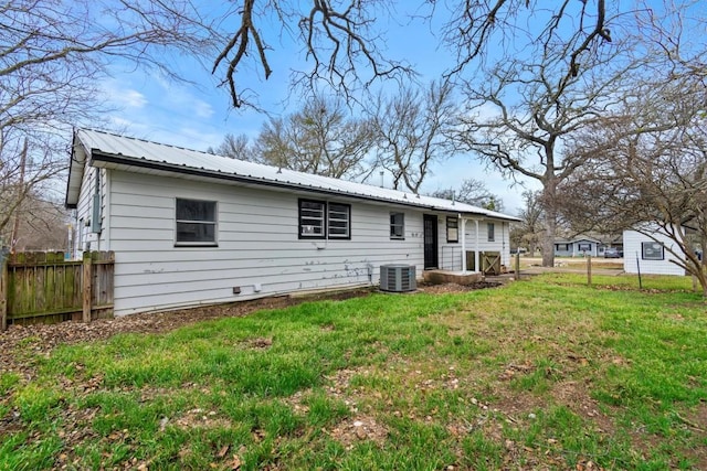 back of house with cooling unit, metal roof, fence, and a lawn