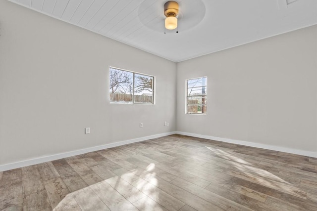 spare room featuring a ceiling fan, baseboards, and wood finished floors