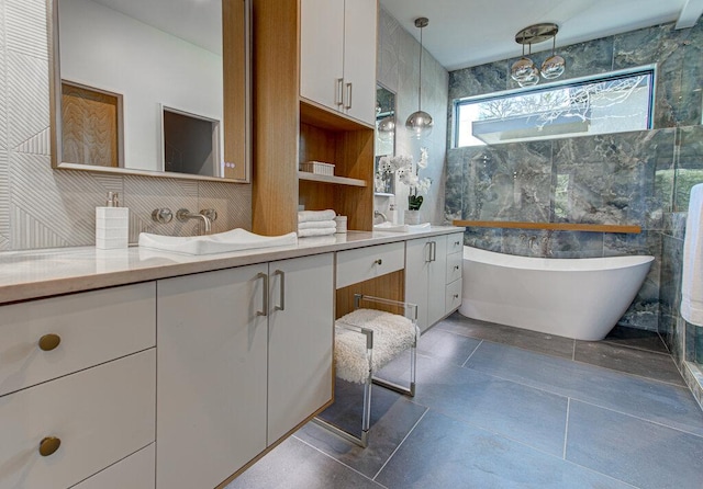 full bathroom with double vanity, a freestanding bath, and tile walls