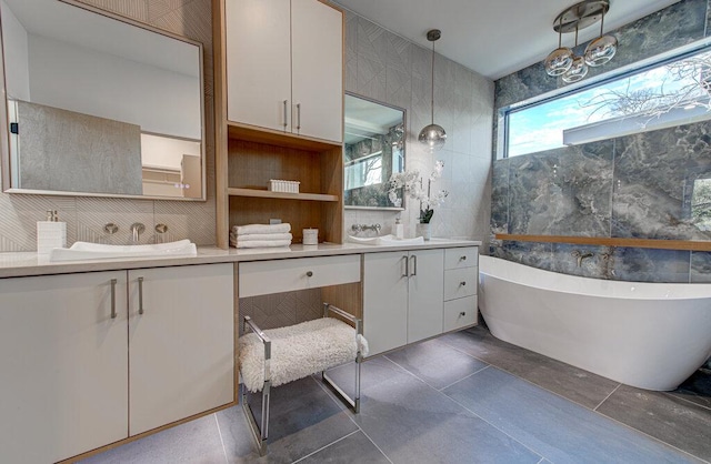 bathroom featuring double vanity, a soaking tub, a sink, and tile walls