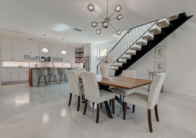 dining space featuring stairway, an inviting chandelier, visible vents, and finished concrete floors