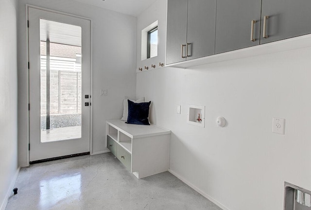 washroom with a healthy amount of sunlight, cabinet space, hookup for a washing machine, and baseboards