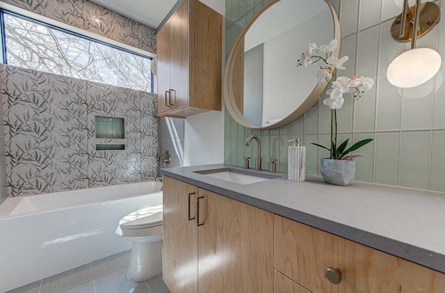 bathroom featuring tile patterned flooring, vanity, toilet, and tile walls