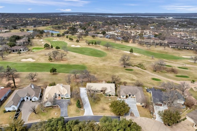 drone / aerial view featuring view of golf course and a residential view