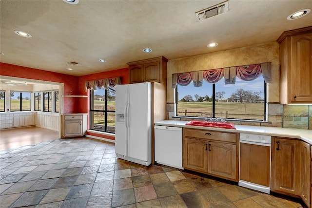 kitchen with recessed lighting, white appliances, visible vents, light countertops, and stone tile flooring