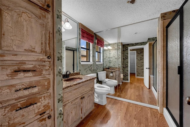 bathroom featuring toilet, a stall shower, a bidet, a textured ceiling, and wood finished floors