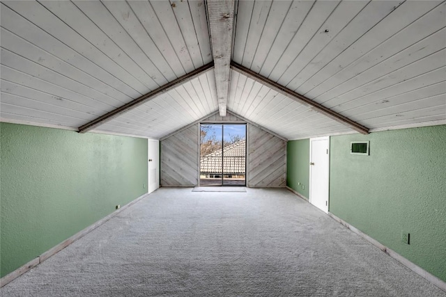 bonus room featuring vaulted ceiling with beams, a textured wall, and carpet floors