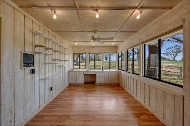 unfurnished sunroom featuring a ceiling fan and track lighting