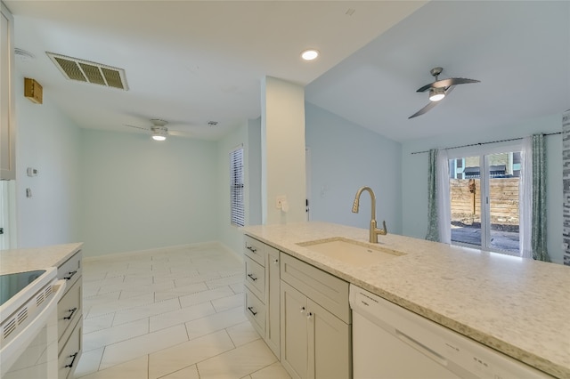 kitchen with visible vents, a ceiling fan, a sink, light stone countertops, and white appliances