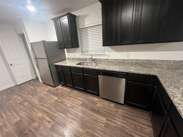 14009 John Aregood Pass, Elgin, TX 78621 - kitchen with appliances with stainless steel finishes, dark cabinetry, and light wood-type flooring