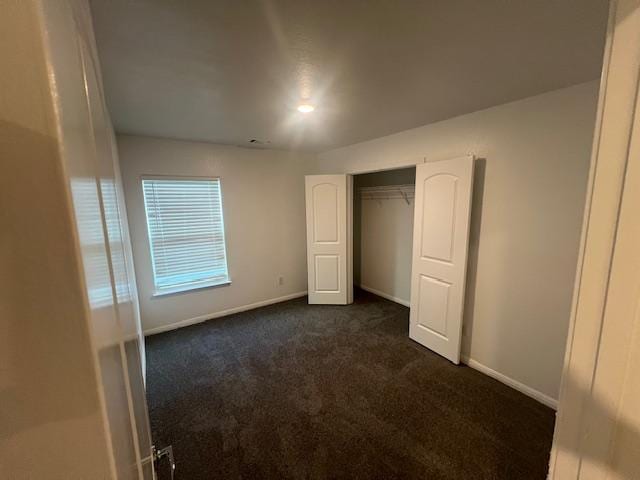 14009 John Aregood Pass, Elgin, TX 78621 - unfurnished bedroom featuring dark carpet and baseboards