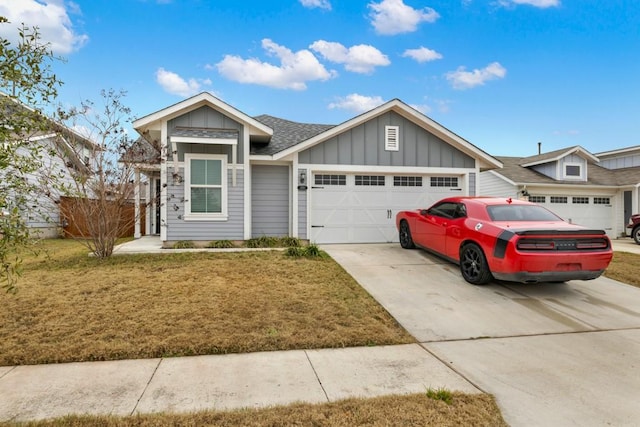 view of front facade with an attached garage, a shingled roof, driveway, a front lawn, and board and batten siding