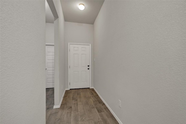 hall featuring baseboards and wood finished floors