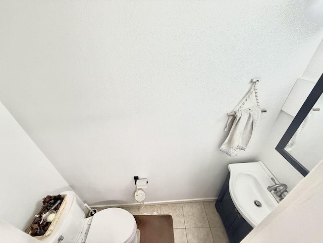 bathroom with baseboards, a sink, toilet, and tile patterned floors