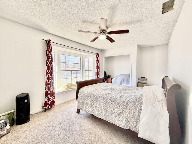 bedroom with carpet, ceiling fan, and a textured ceiling