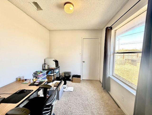 carpeted home office featuring a textured ceiling and baseboards