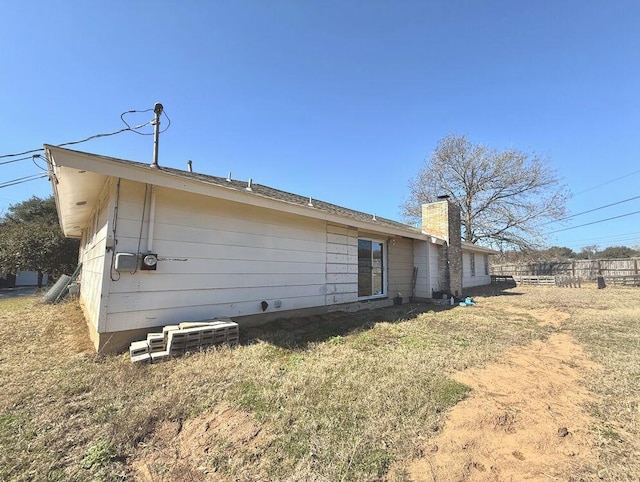 rear view of property with fence and a chimney