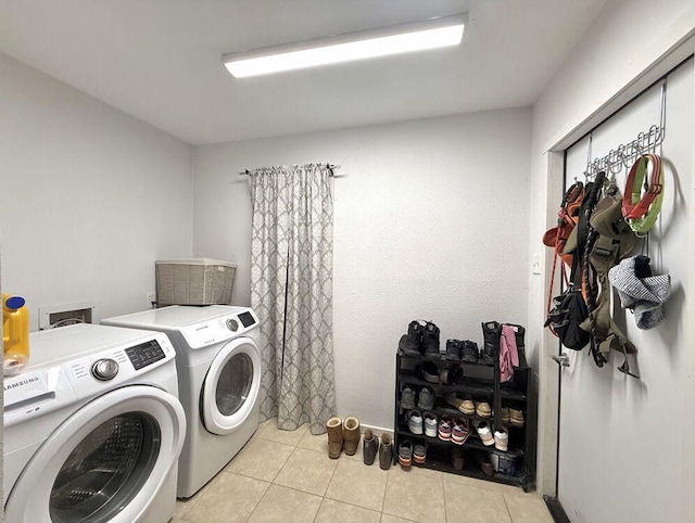 clothes washing area featuring light tile patterned floors, laundry area, and washing machine and clothes dryer