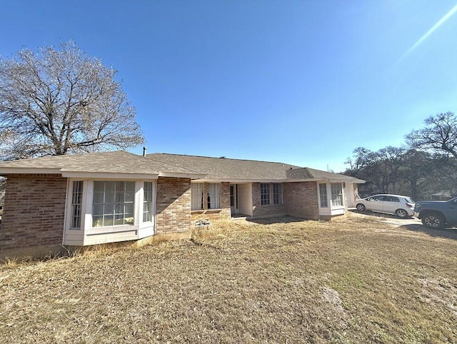 single story home featuring brick siding