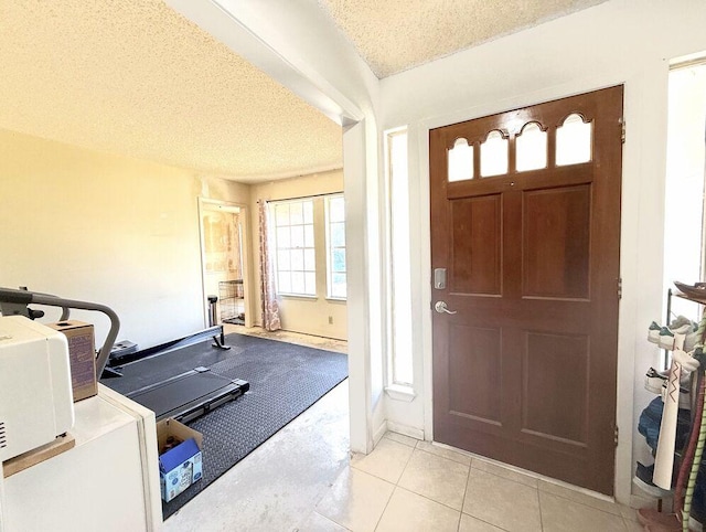 entryway featuring light tile patterned flooring and a textured ceiling