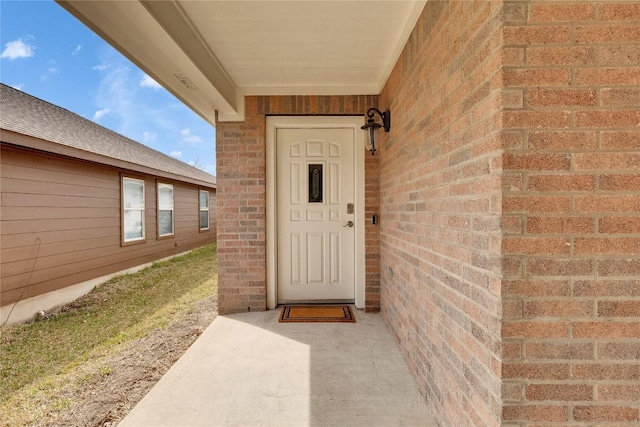 doorway to property featuring brick siding